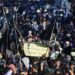Amankan Demo di KPU dan DPR/MPR RI, Polisi Turunkan 3.055 Personel 2 Pengunjuk rasa membawa poster saat menyampaikan aspirasinya di depan kompleks Parlemen, Senayan, Jakarta, Selasa (19/3/2024)