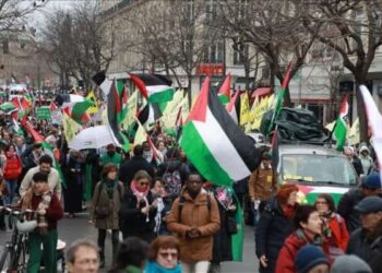 Pengunjuk rasa mengibarkan bendera Palestina untuk menuntut gencatan senjata segera di Jalur Gaza