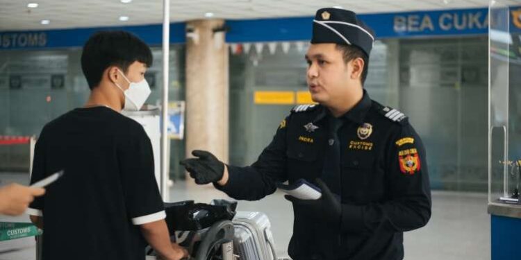 Petugas sedang memeriksa penumpang.