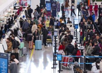 Penumpang mengantri untuk check-in di Bandara Internasional Beijing Daxing di Beijing, China.