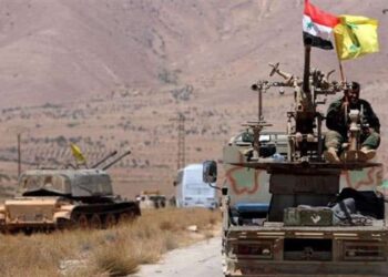 Sebuah kendaraan militer mengibarkan bendera Suriah dan Hezbollah di Kota Qalamoun, Suriah.