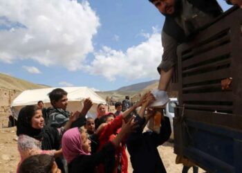Anak-anak berkerumun di samping kendaraan yang memuat bantuan banjir di Distrik Borka, Provinsi Baghlan, Afghanistan, pada 12 Mei 2024.