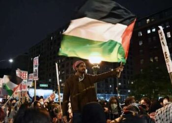 Seorang pria mengibarkan bendera Palestina dalam aksi unjuk rasa pro-Palestina yang digelar di luar Universitas Columbia di New York, Amerika Serikat, 23 April 2024.