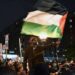Seorang pria mengibarkan bendera Palestina dalam aksi unjuk rasa pro-Palestina yang digelar di luar Universitas Columbia di New York, Amerika Serikat, 23 April 2024.