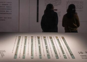 Dua orang pengunjung memperhatikan pameran potongan bambu yang ditemukan di makam pejabat yang hidup pada masa Dinasti Qin (221 SM-207 SM), di Museum Provinsi Hubei di Wuhan, China, pada 30 April 2024.
