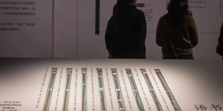 Dua orang pengunjung memperhatikan pameran potongan bambu yang ditemukan di makam pejabat yang hidup pada masa Dinasti Qin (221 SM-207 SM), di Museum Provinsi Hubei di Wuhan, China, pada 30 April 2024.