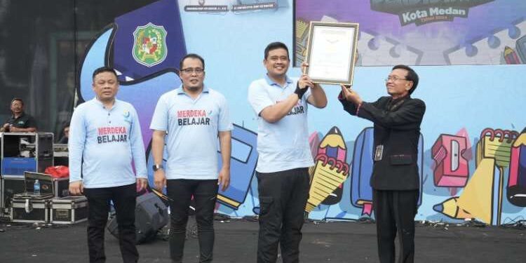 Gebyar Pendidikan Kota Medan Pecahkan Dua Rekor MURI Dunia 1 Wali Kota Medan, Bobby Nasution, menerima piagam penghargaan rekor MURI Dunia yang diserahkan oleh Direktur Operasional MURI, Yusuf Ngadri, pada puncak Gebyar Pendidikan Kota Medan 2024, di Lapangan Benteng Medan, Minggu (26/5/2024).