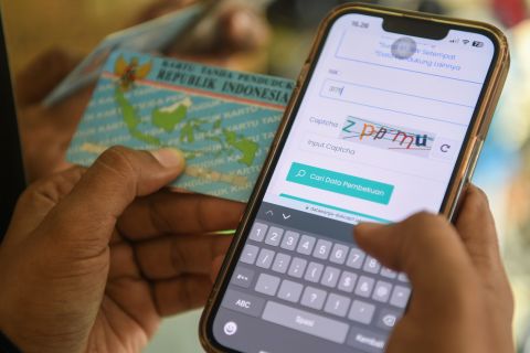 Satu Alamat Rumah di DKI Maksimal Dihuni Tiga KK 1 Warga mengecek nomor induk kependudukan (NIK) dengan ponselnya.