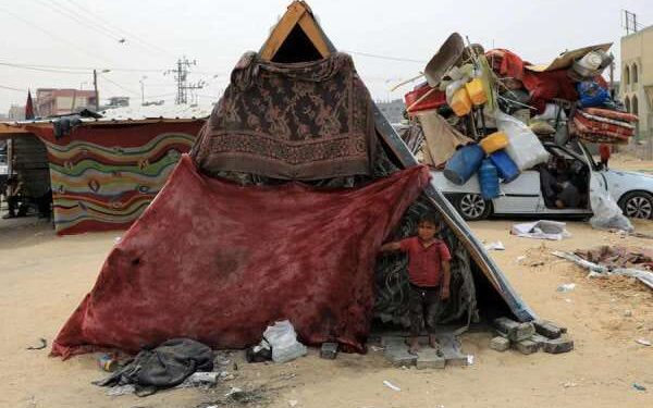 Rute Bantuan ke Gaza, Israel Umumkan Buka Perlintasan Baru 1 Seorang anak laki-laki Palestina berdiri dan melihat ke luar tenda di kamp sementara di kota Rafah, Jalur Gaza selatan, pada 10 Mei 2024.