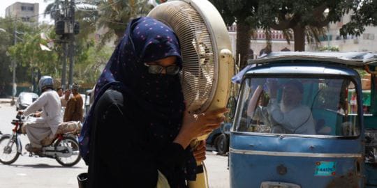 Gelombang Panas Ekstrem Landa Pakistan, Suhu Tembus 52 Derajat Celsius 1 Seorang perempuan Pakistan membawa kipasnya menuju tempat reparasi di Karachi.