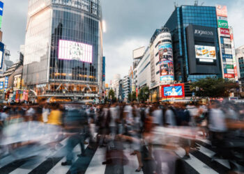 Orang-orang berjalan di persimpangan jalan Shibuya, Tokyo, Jepang.
