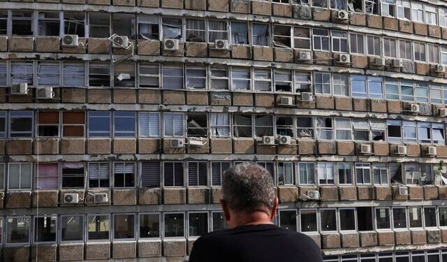 Seorang pria melihat sebuah bangunan yang rusak di lokasi ledakan di Tel Aviv, Israel (19/7/2024).