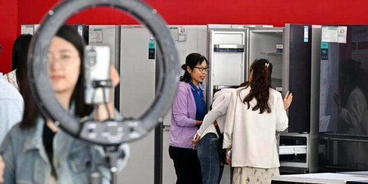 Konsumen mempelajari kebijakan yang relevan selama acara tukar tambah barang konsumen di Kota Qingdao, Provinsi Shandong, China Timur.