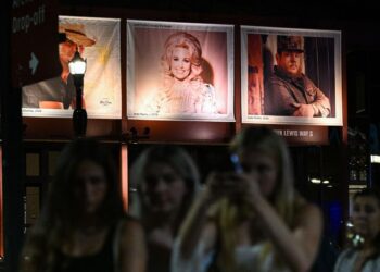 Para penggemar berkumpul di dekat foto mendiang penyanyi dan penulis lagu AS Dolly Parton yang dipajang di Country Music Hall of Fame and Museum di Nashville, Tennessee, AS.