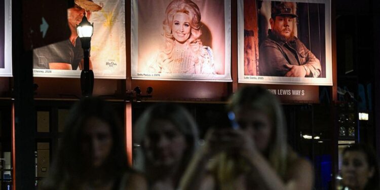 Para penggemar berkumpul di dekat foto mendiang penyanyi dan penulis lagu AS Dolly Parton yang dipajang di Country Music Hall of Fame and Museum di Nashville, Tennessee, AS.